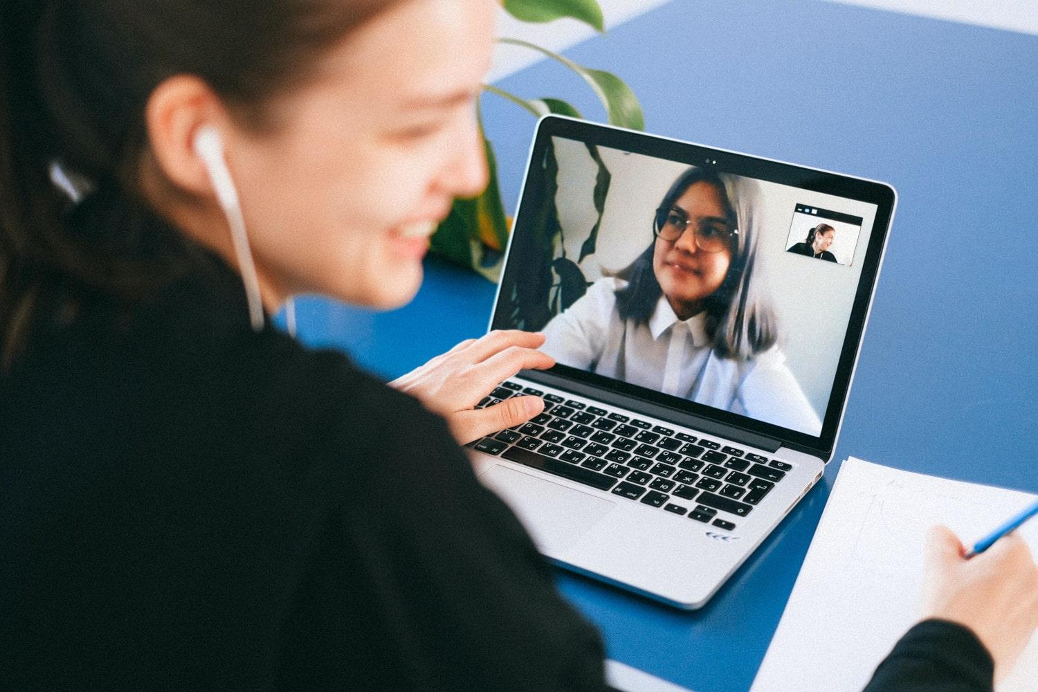 Mujer estudia programación con una compañera de manera virtual